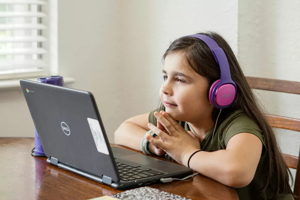 A girl using the computer finding tips on fashion on social media.