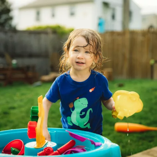 a little girl playing in a pool with toys